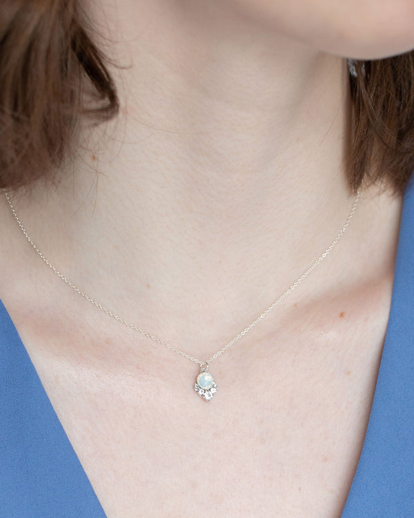 A close view of a bridesmaid wearing the petite version of the Celestial Crystal Drop Necklace in silver with white opal crystals.