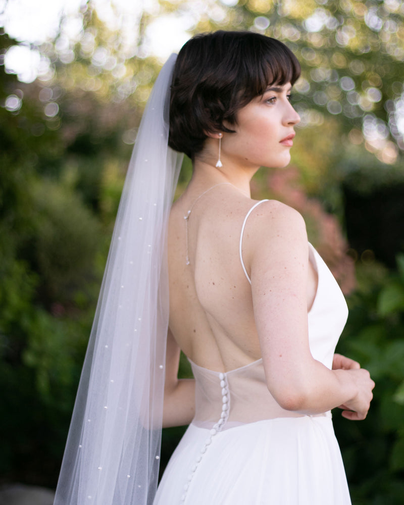 A bride wears the Akina Pearl Veil in light ivory.
