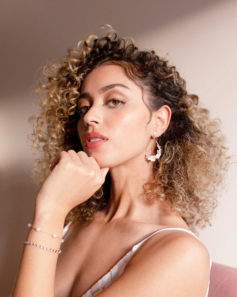A model wears the Astra Floral Statement Earrings with the matching Astra Bracelet.