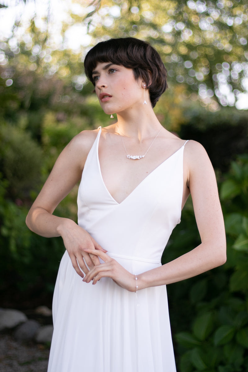 A bride models the Belle Fleur Necklace in silver with ivory flowers.