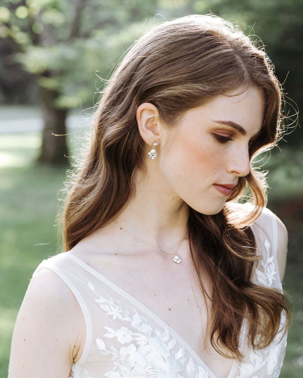 A bride with auburn hair wears the Celestial Pearl Drop Jewellery Set in silver with cream pearls.