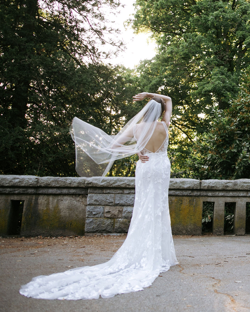 Back view of a bride with a deep-V back wearing the Lily Fingertip veil.
