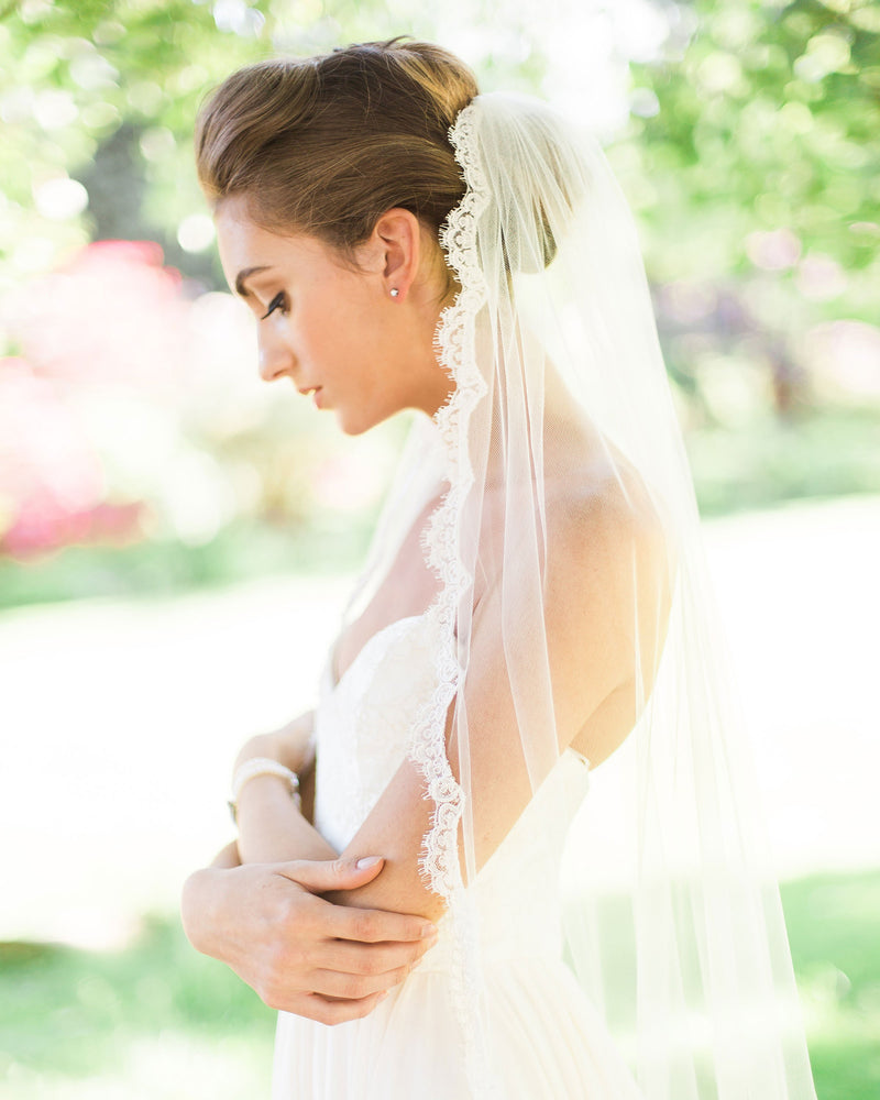 A side view of a bride wearing the Magnolia Lace Veil in fingertip length.