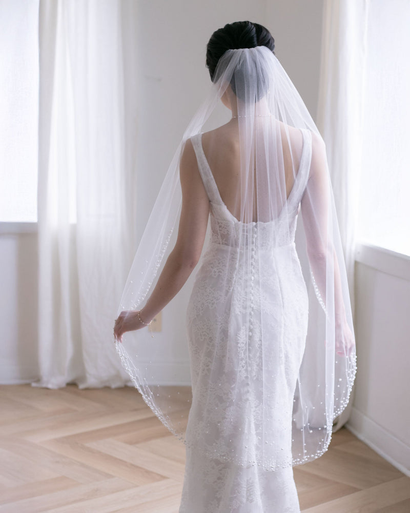 A back view of a bride wearing the Kalina Short Veil in fingertip length.