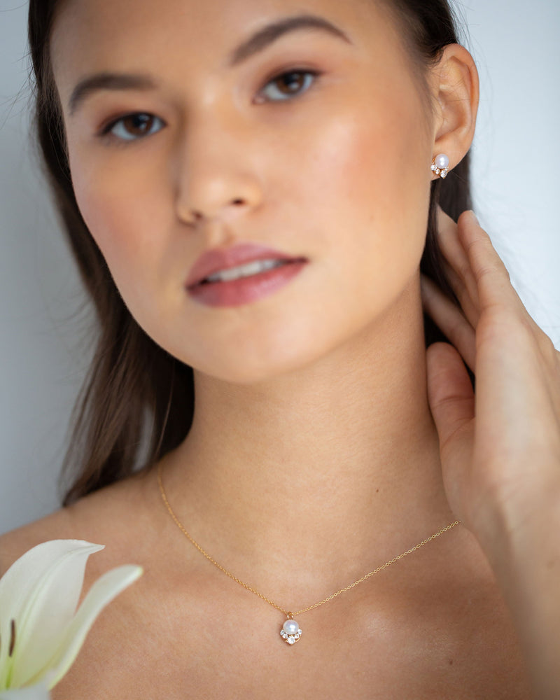 A model wears the petite size of the Celestial Pearl Stud Jewellery Set in gold with freshwater pearls.