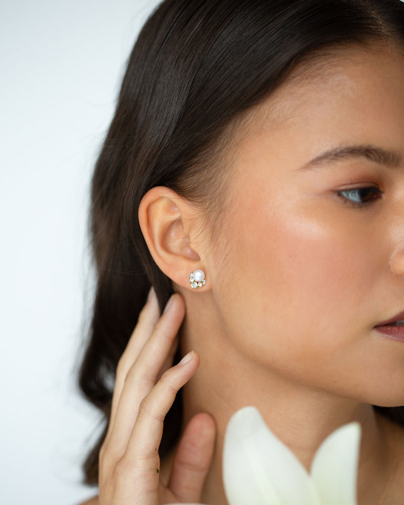A bridesmaid wears the Petite Celestial Pearl Cluster Earrings in gold.