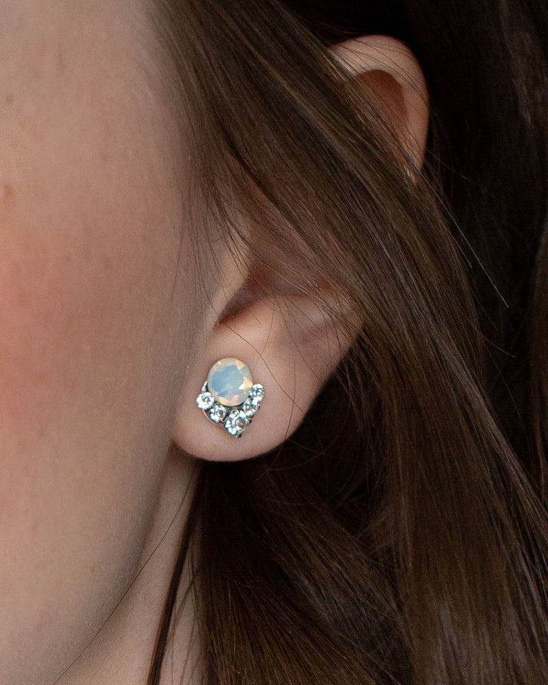 A close view of a bridesmaid wearing our Celestial Crystal Cluster Earrings in silver with white opal crystals.