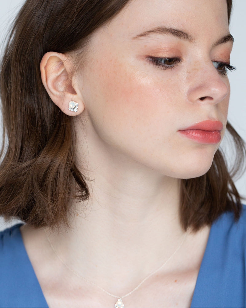 A bridesmaid in a blue top wears our Celestial Crystal Cluster Earrings and matching necklace in silver with white opal crystals. She wears the petite 6mm size.
