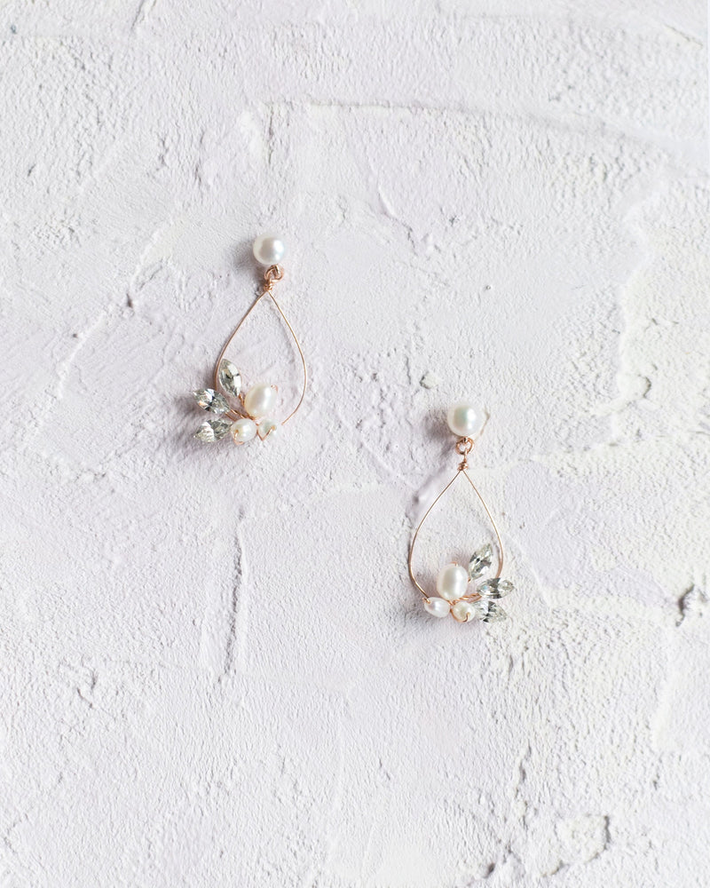 Flatlay view of the Lovely Pearl Earrings in rose gold.