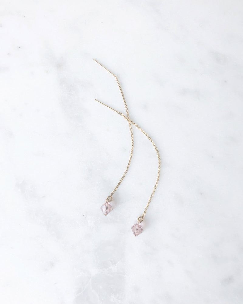 Flatlay of the Prism Threader Earrings in gold with blush crystals from our bridesmaid jewellery collection.