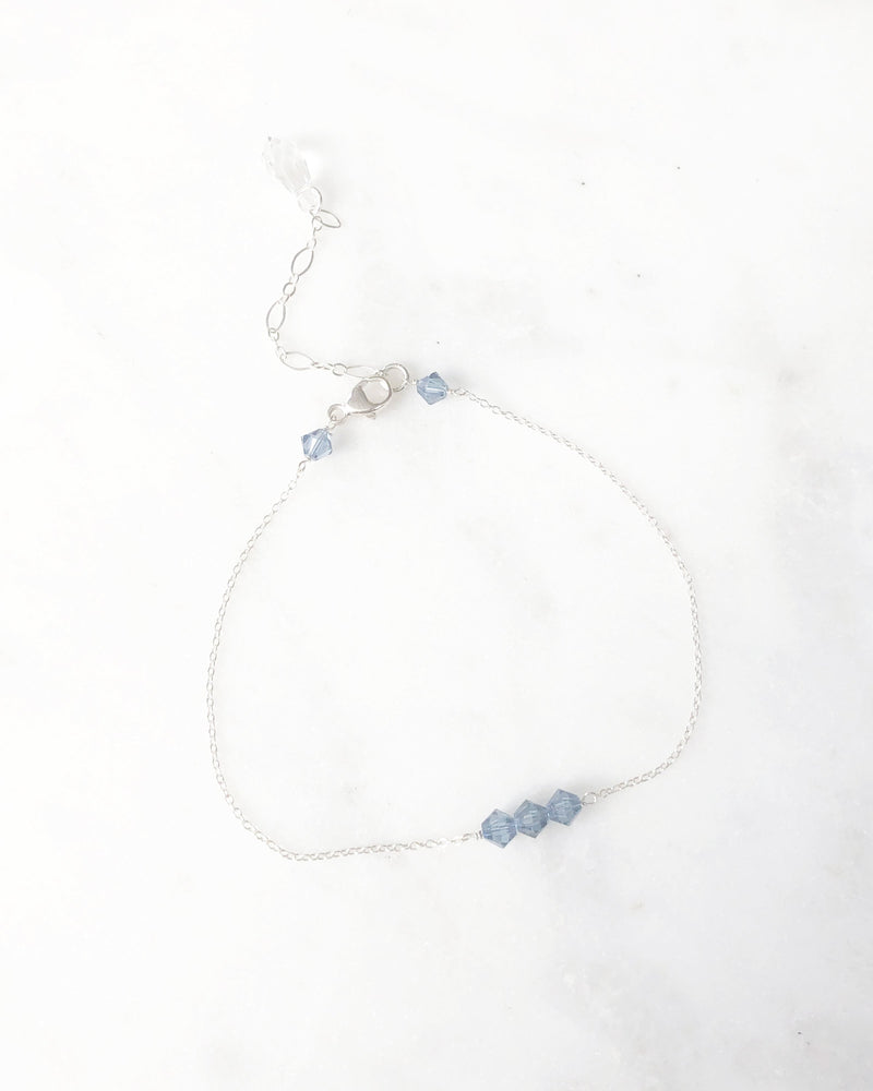 Flatlay of the Stardust Bridesmaid Bracelet in silver with lake blue crystals.