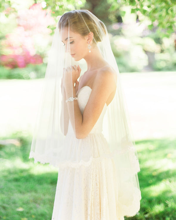 Model wearing the Amara two-layer lace fingertip bridal veil with the blusher to the front.