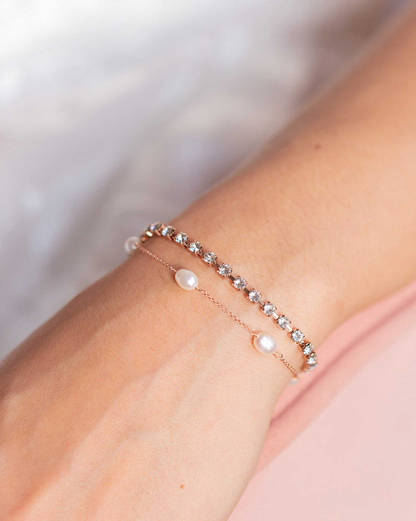Close model view of the double layer Astra Bracelet in rose gold. Tennis bracelet of dazzling crystals combined with a layer of floating pearls.