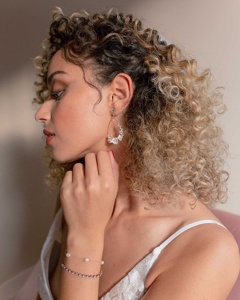 A model wears the Astra Floral Statement Earrings with the matching Astra Bracelet.
