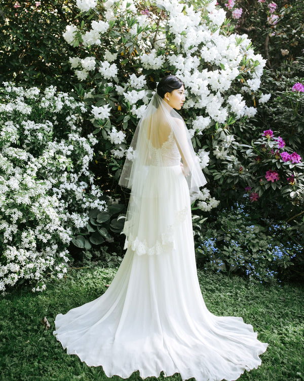 A bride wears the Azalea two-layer veil with a lace border on bottom layer and soft blusher worn to the back.