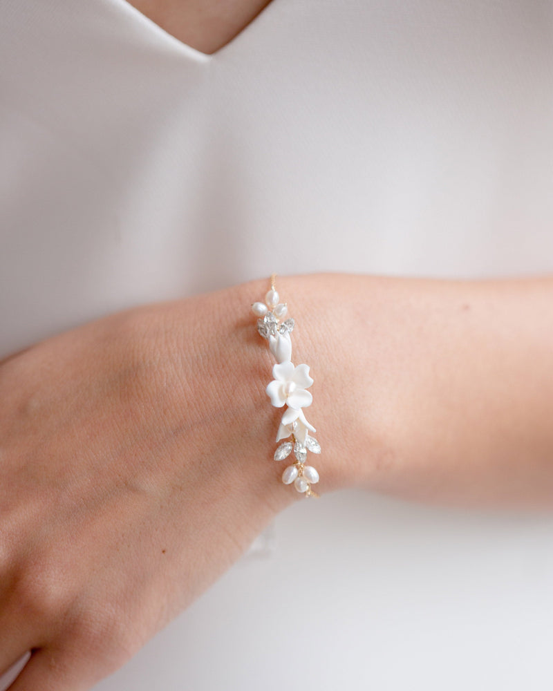 Close model view of the Belle Fleur Bracelet in gold with ivory flowers.