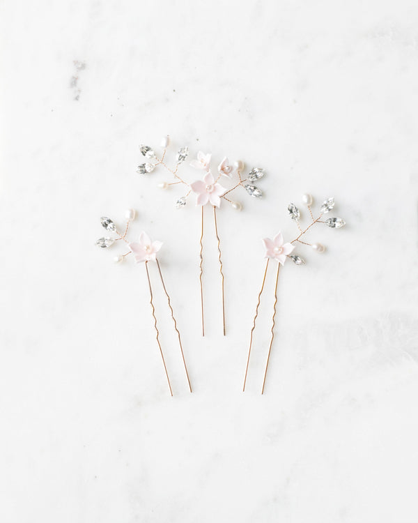 Flatlay of the trio of Belle Fleur Hair Pins. The pins are rose gold, with blush flowers, pearls, and crystals.