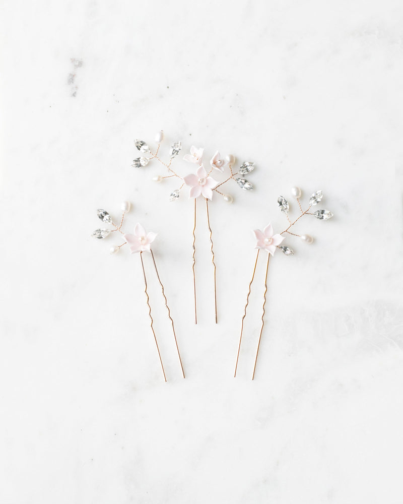 Flatlay of the trio of Belle Fleur Hair Pins. The pins are rose gold, with blush flowers, pearls, and crystals.