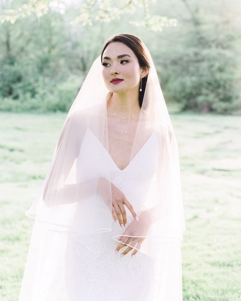 Model wearing calla long wedding veil with blusher
