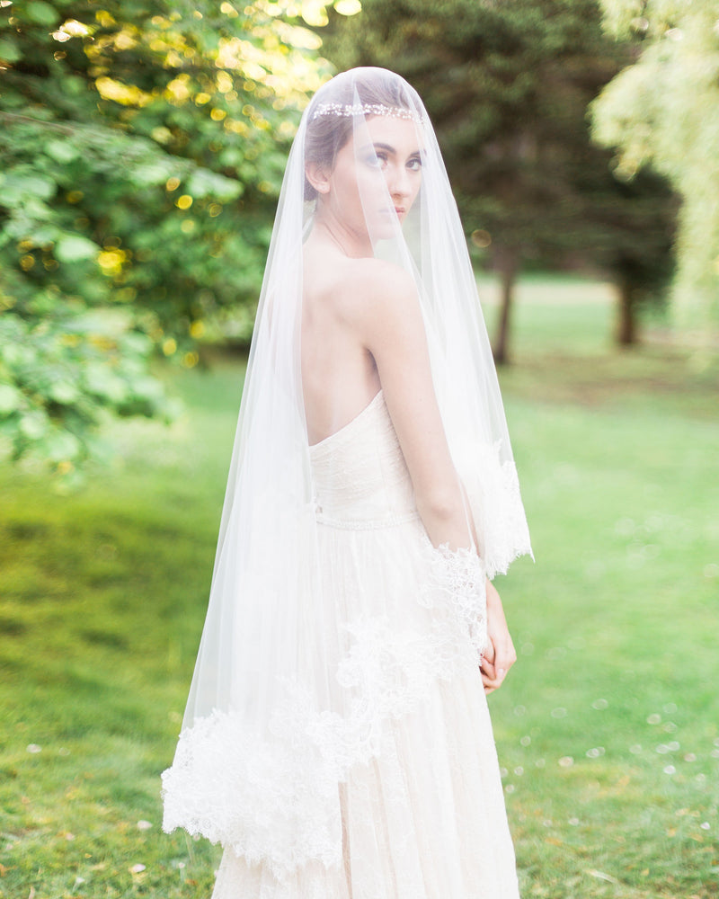 model wears cassia chantilly lace fingertip wedding veil with  blusher