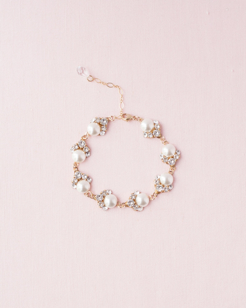 Flatlay of the Celestial Pearl Cluster Bridal Bracelet in gold with cream pearls.
