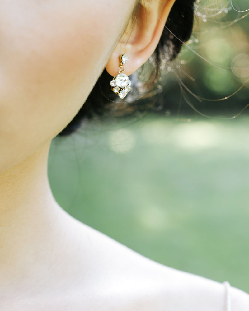 A close view on model of the Celestial Crystal Drop Earrings in gold, with classic crystal.