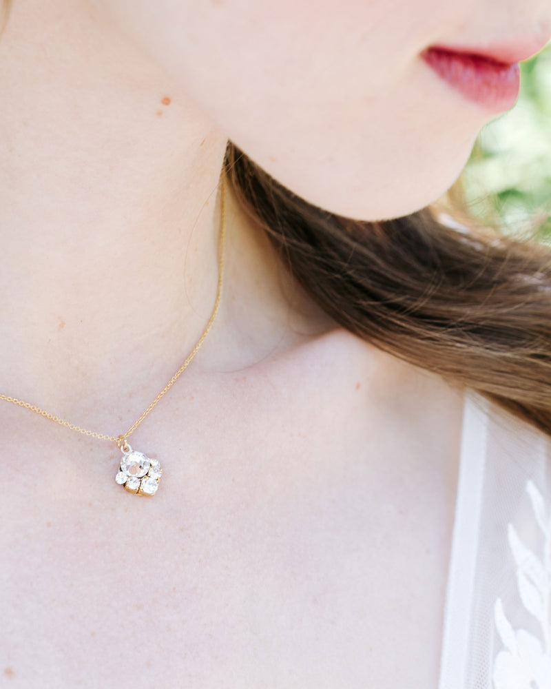 A close-up view of a bride wearing the Celestial Crystal Drop Bridal Necklace in gold with all crystal.