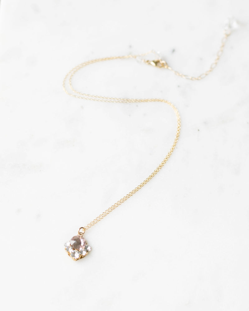 Flatlay of the Celestial Crystal Drop Necklace in gold with blush crystal.