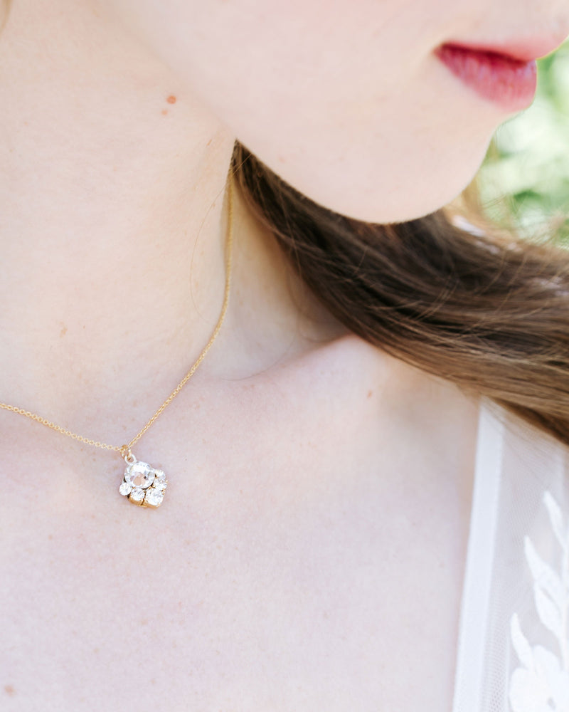 A close-up view of a model wearing the Celestial Crystal Drop Bridal Necklace in gold with all crystal.