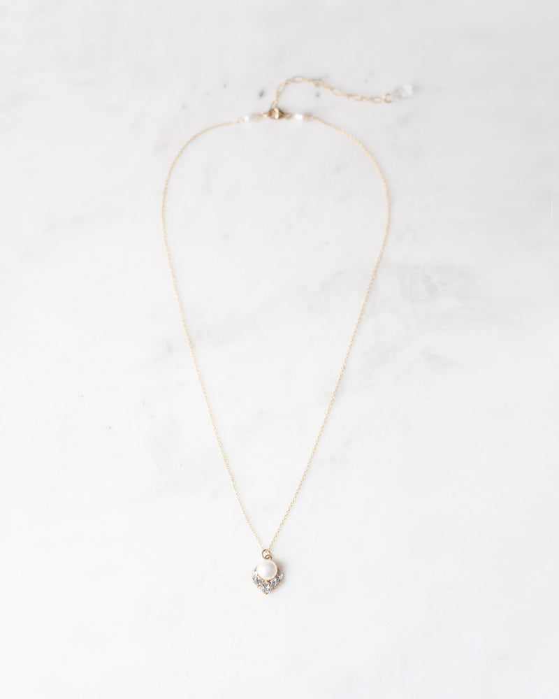 Flatlay of the Celestial Pearl Drop Necklace in gold with a natural freshwater pearl.