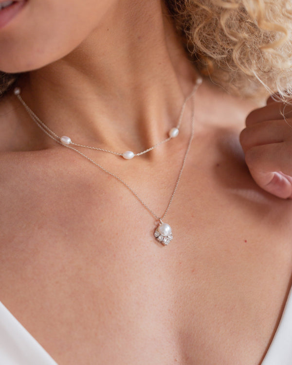 A close up on model of the Celestial Pearl Layered Necklace in silver with freshwater pearls.