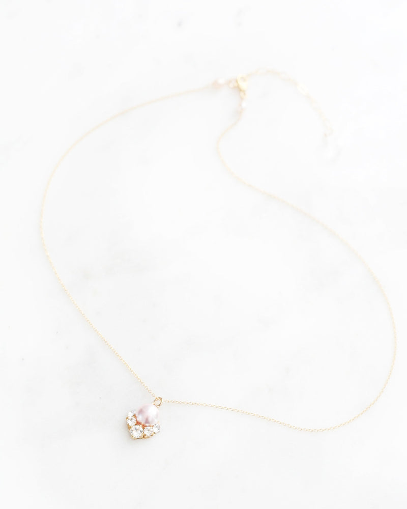 Flatlay of the Celestial Pearl Drop Necklace in gold with a blush pearl.