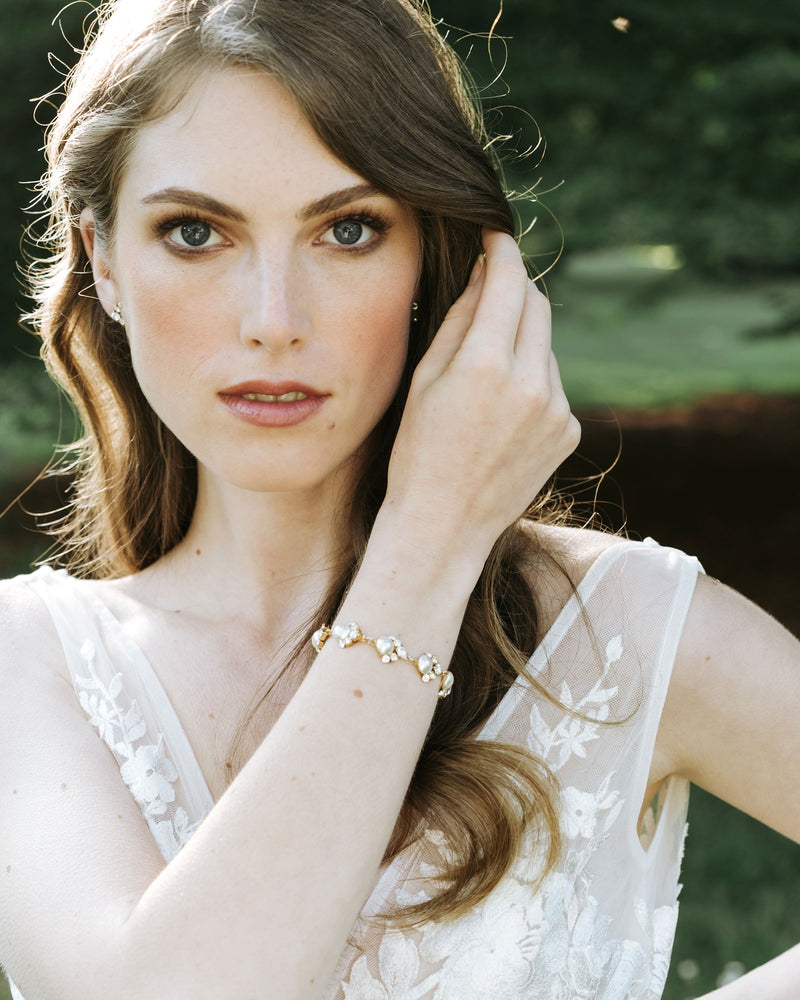 A bride wears the Celestial Pearl Cluster Bracelet in gold.