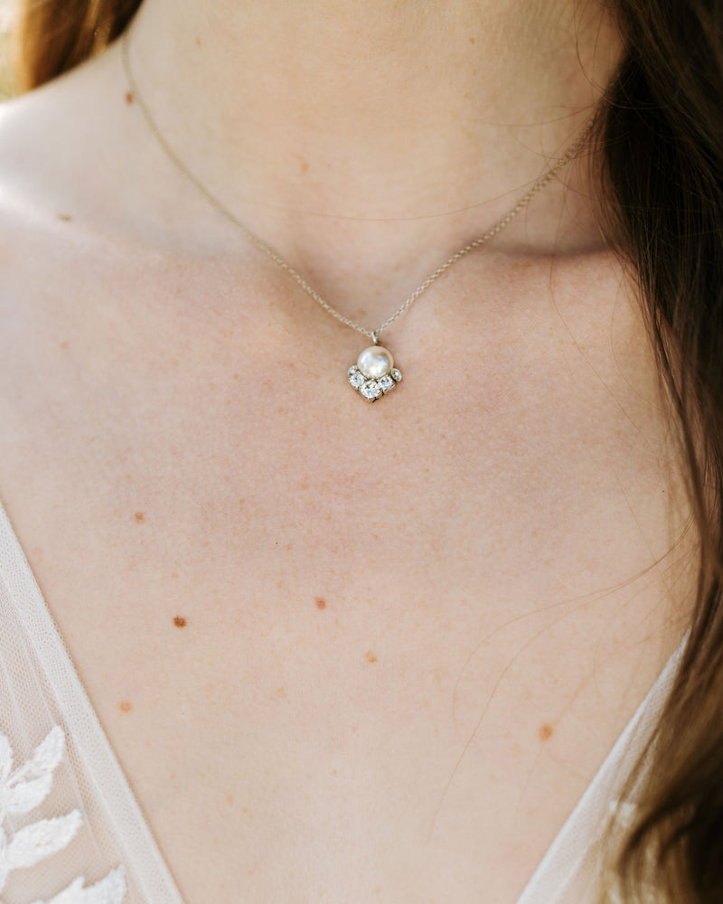 A close model view of the Celestial Pearl Drop Necklace in silver with a cream centre pearl.