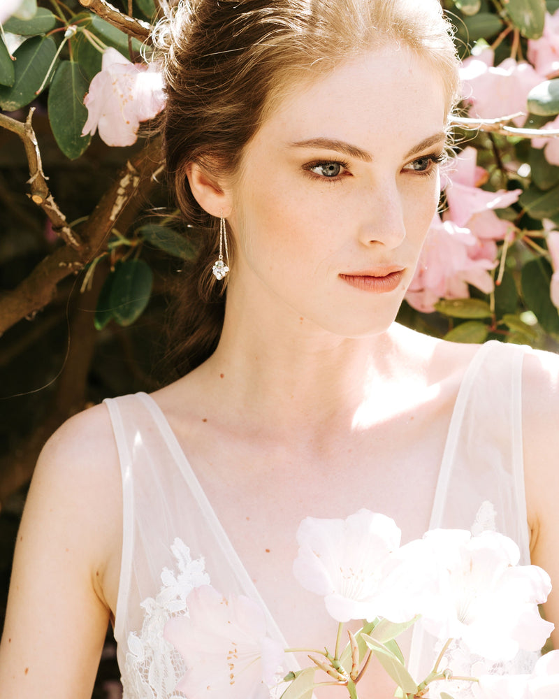 A bride is wearing the Celestial Crystal Threader Earrings in silver/crystal.