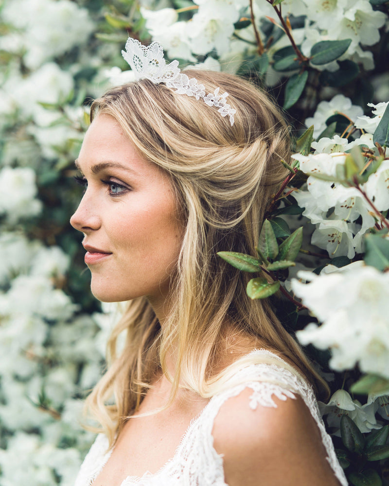 A bride wears a delicate Chantilly lace bridal crown.