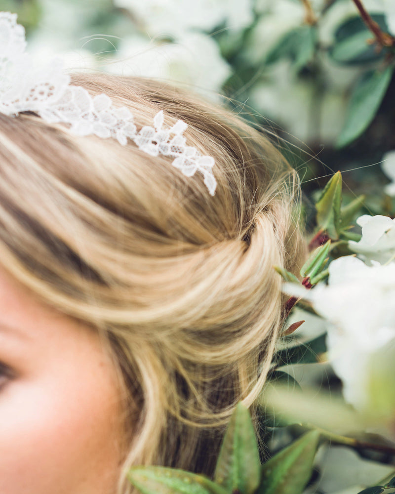 Close details of a bride wearing a Chantilly lace wedding crown.
