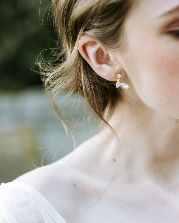 A close model view of the Crystal Leaf earrings in gold.