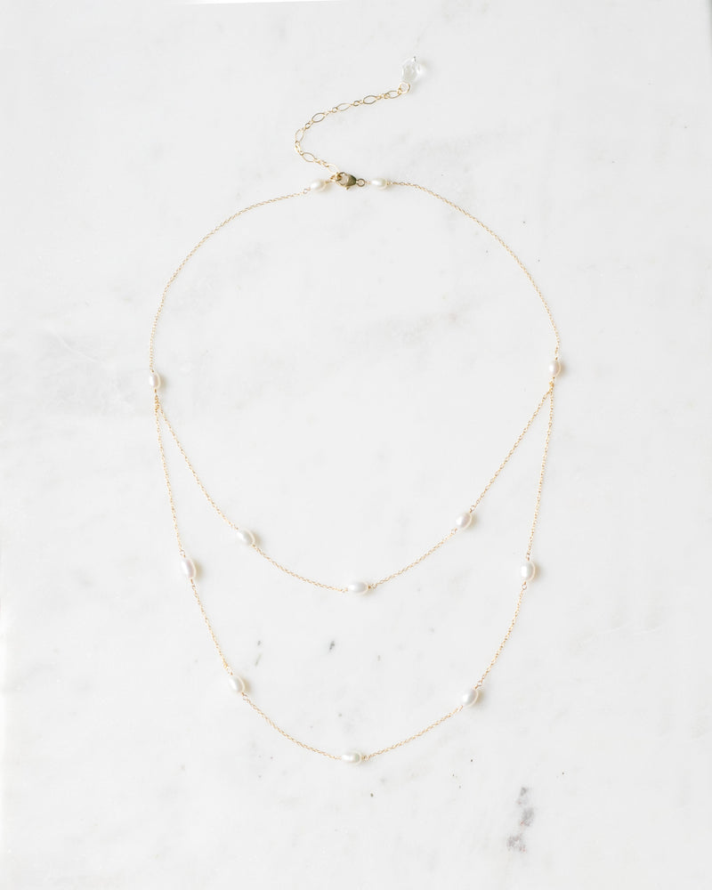 Flatlay of the Dainty Pearl Layered Necklace in gold with freshwater pearl.