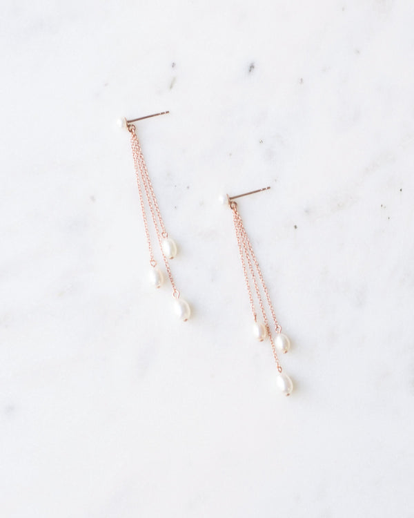 Flatlay of the Dainty Pearl Trio Earrings in rose gold.
