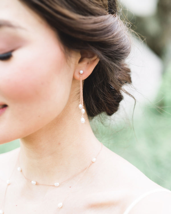Close-up on model of the Dainty Pearl Trio Earrings in rose gold, paired with the Dainty Pearl Layered Necklace.