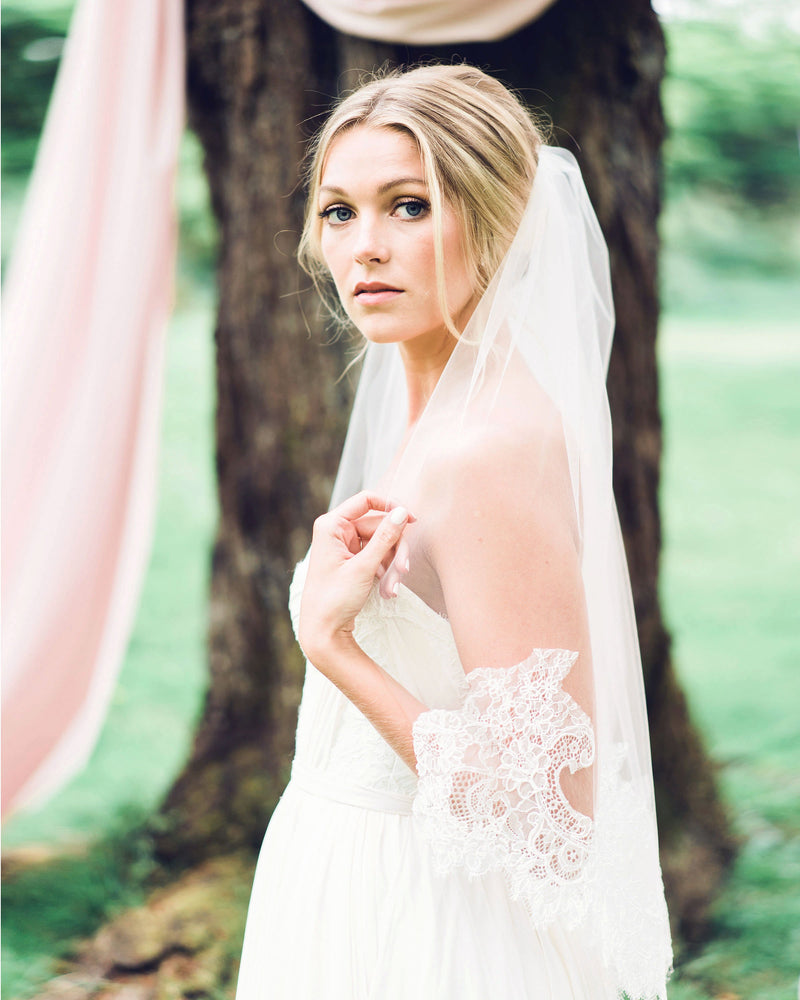 Bride wearing waist lace veil with intricate Chantilly lace.
