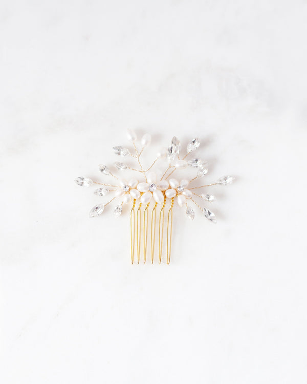 Flatlay of a pair of Delicate Bridal Combs in gold, with pearls and crystals.
