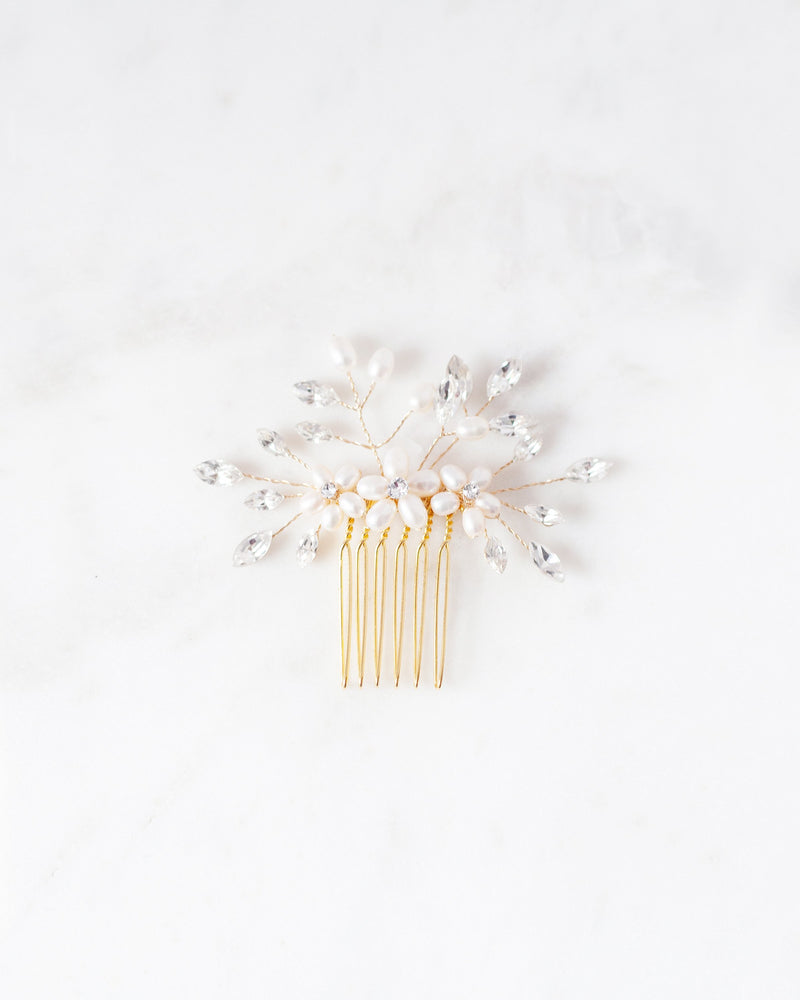 Flatlay of a pair of Delicate Bridal Combs in gold, with pearls and crystals.