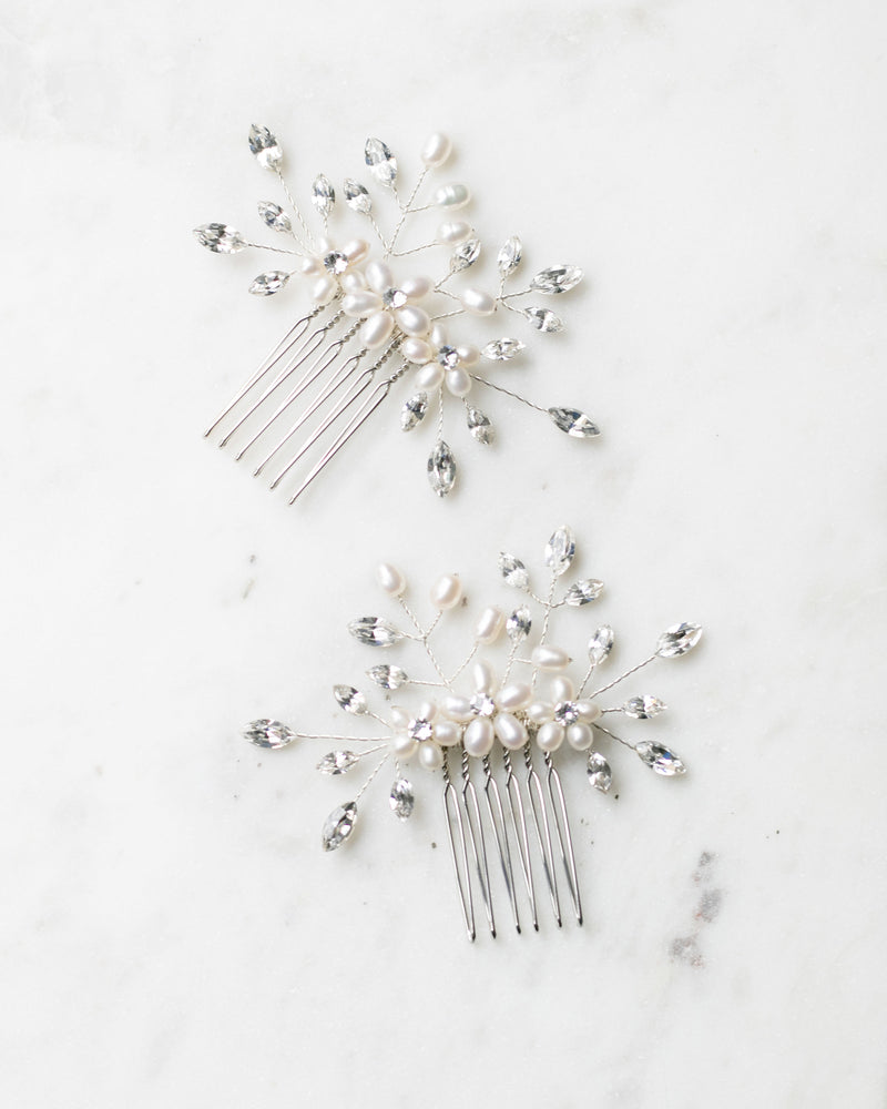 Flatlay of a pair of Delicate Bridal Combs in silver, with pearls and crystals.