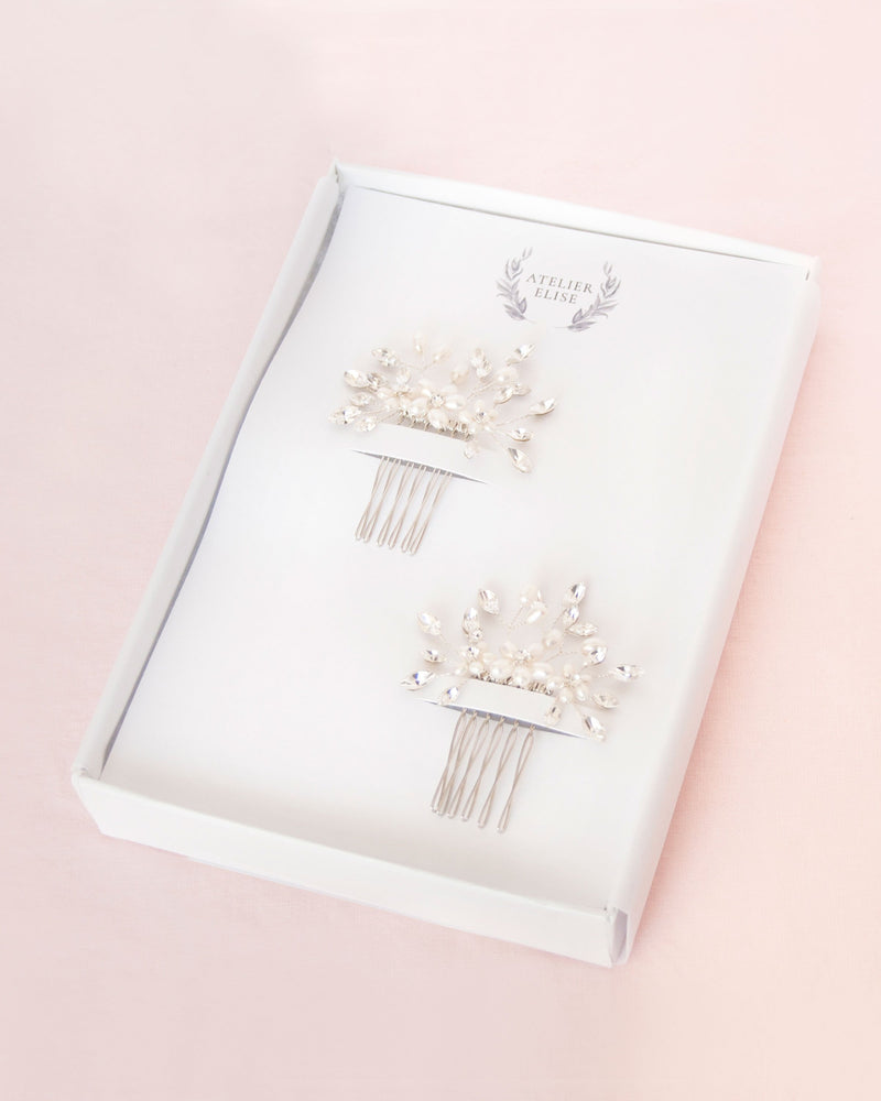 Set of two delicate combs with freshwater pearl flowers and crystals in silver. Prettily packaged in a white jewellery box.