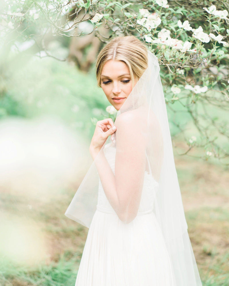 A model poses in our Delphine Gathered Veil. Both layers of the two-layer veil are styled to the back.