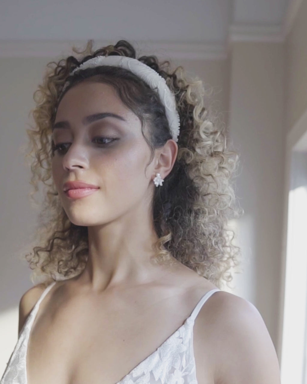 Video of a model wearing the Camellia Padded Headband with beaded lace.