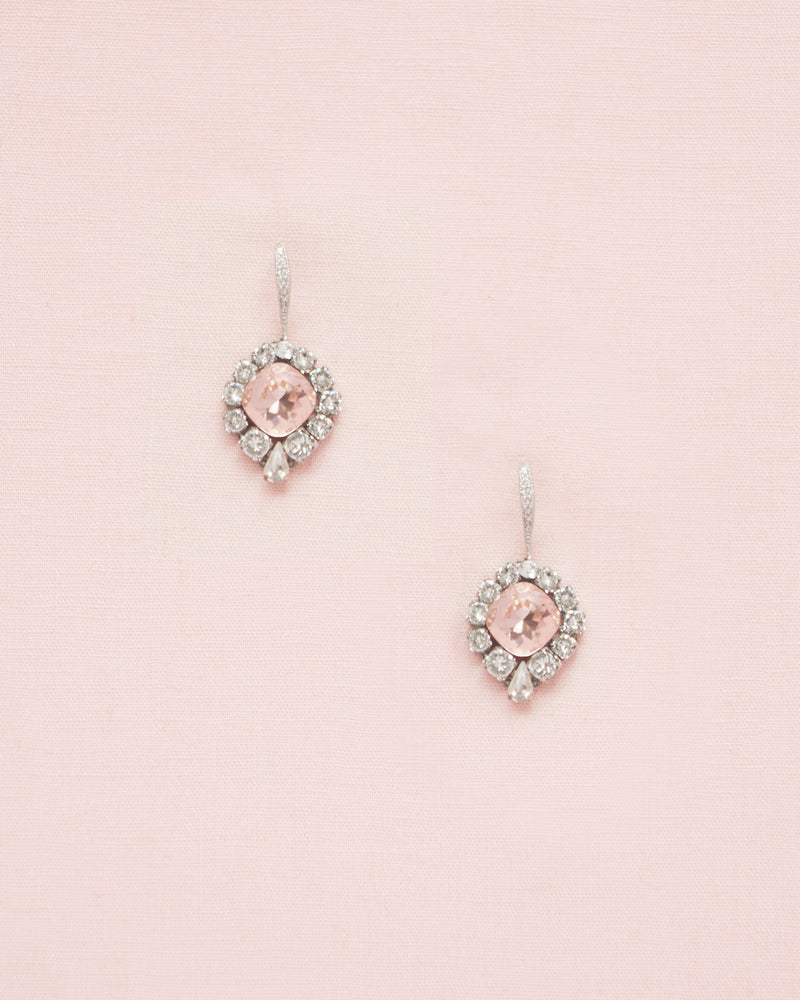 Flatlay of the Enchanted Crystal Drop Earrings in silver with blush crystal centres. The pave crystal hook version is shown.