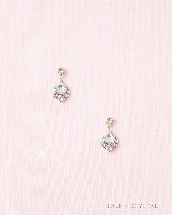 A flatlay view of the Celestial Crystal Drop Earrings in gold, all crystal.